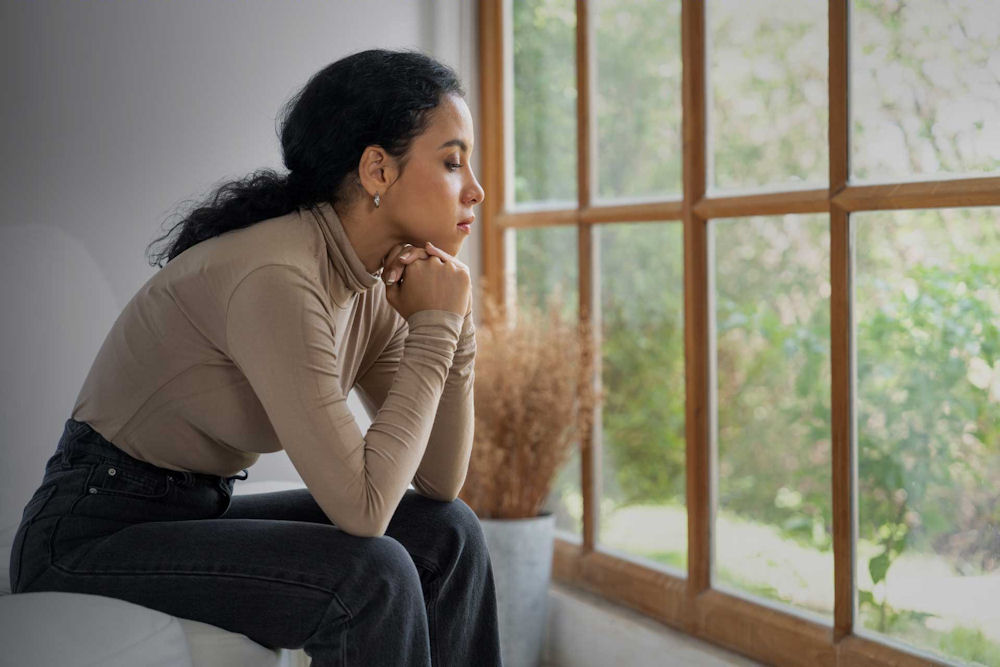 Woman experiencing emotional exhaustion and burnout while sitting alone at home