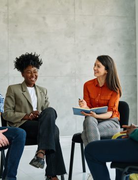 Group psychotherapy. Persons sitting in circle and talking. People meeting. Psychotherapy training, business lecture or conference. Man woman support group. Young businesspeople having a meeting in the office, young businesswoman entrepreneur